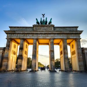 Braniborská brána v Berlíně zalitá zlatým večerním světlem, symbol evropské kultury a propojení jazyků v digitální éře online vzdělávání.